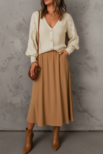 Load image into Gallery viewer, White woman in cream cardigan with camel midi skirt
